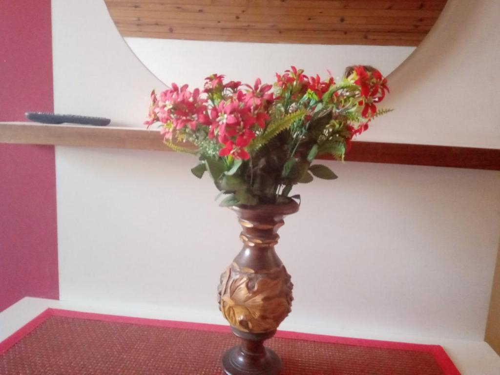 a vase with flowers in it sitting on a rug at Studio Krejović sa zasebnim kupatilom i čajnom kuhinjom in Zlatibor