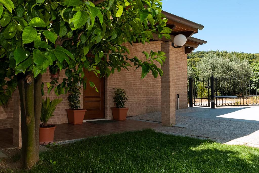 a brick building with a door and a tree at La casa de Rocche in Cupra Marittima