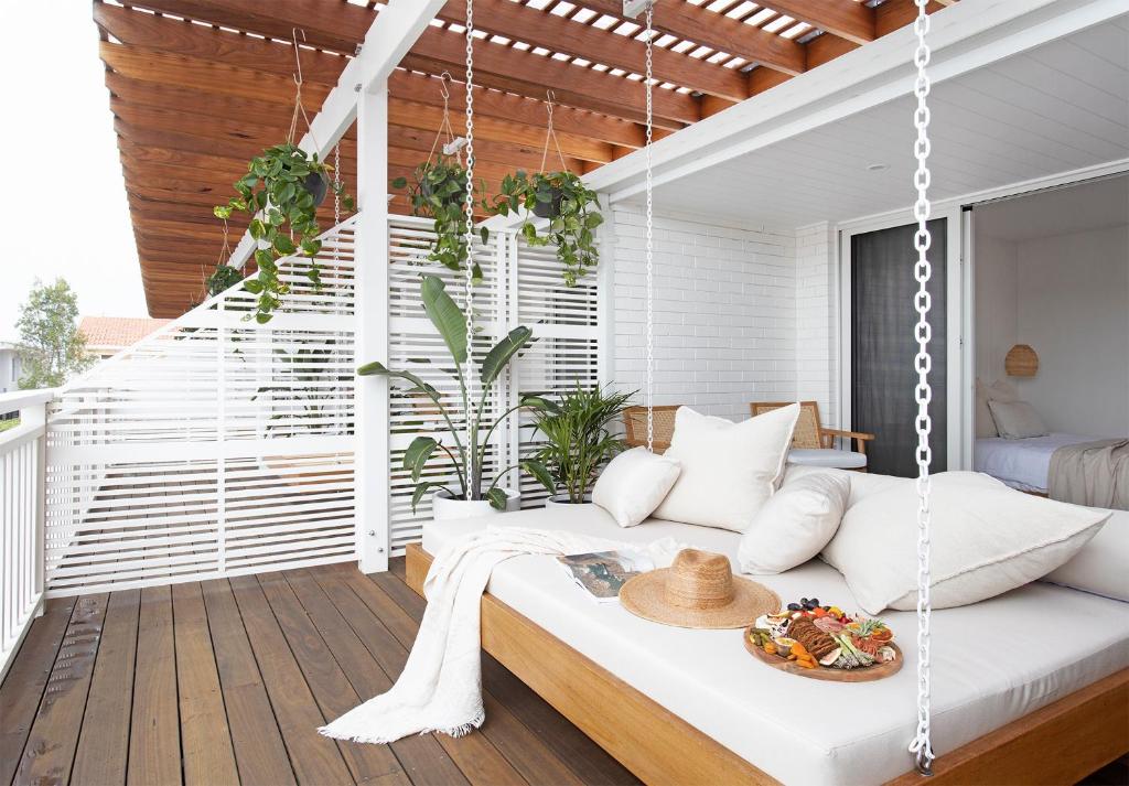 a swinging bed in a room with a balcony at Crystal Pacific Palm Beach in Gold Coast