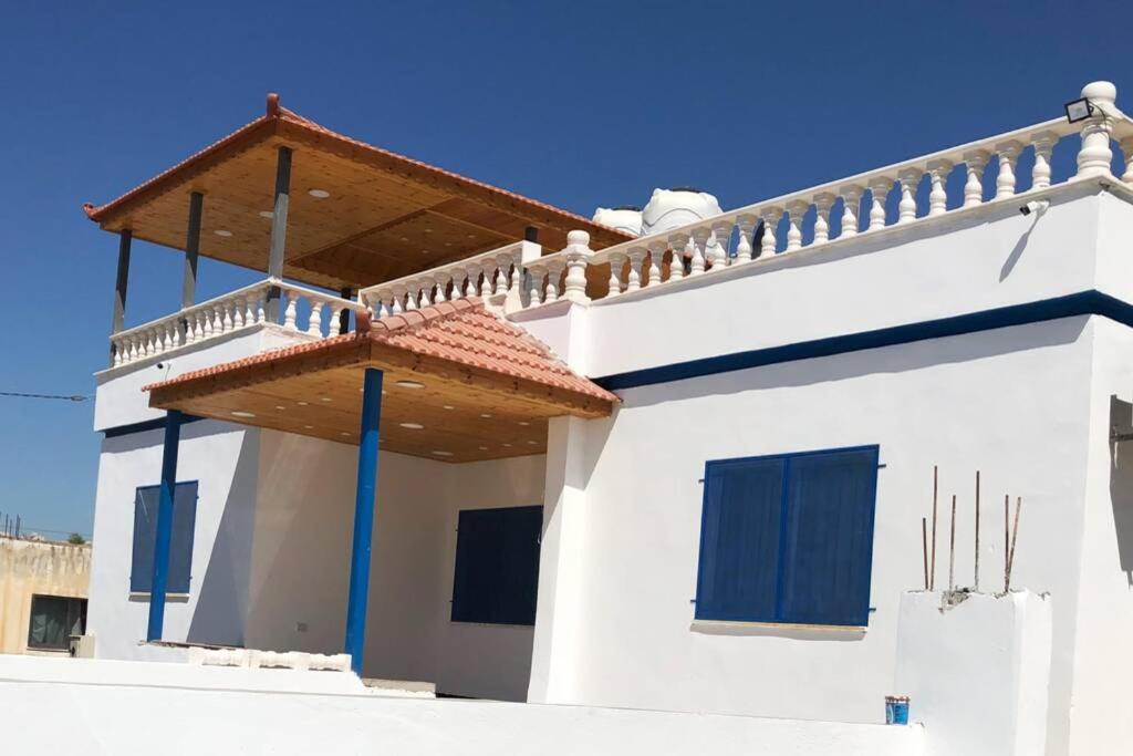 ein weißes Haus mit Balkon darüber in der Unterkunft Gedara Guesthouse: enjoy unforgettable scenes in Um Qeis