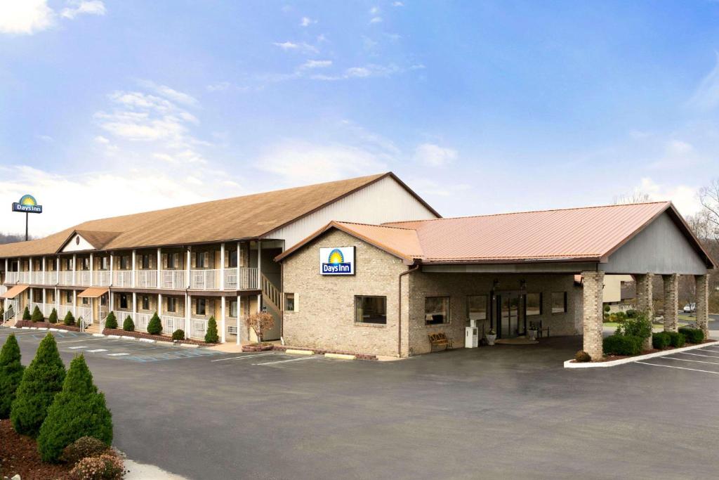 a front view of a hotel with a parking lot at Days Inn by Wyndham Huntington in Pea Ridge