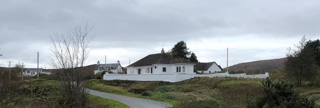 a white house in the middle of a field at Skerrols in Broadford
