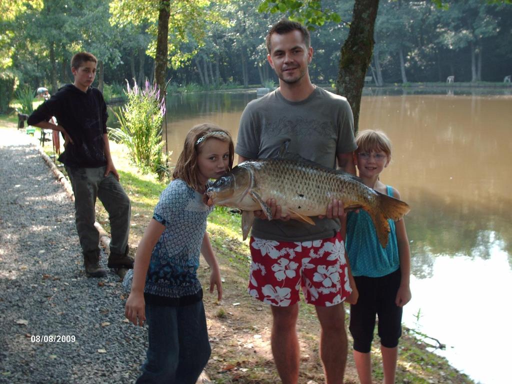 een man en twee kinderen met een grote vis bij le Gite de illian in Saint-Michel