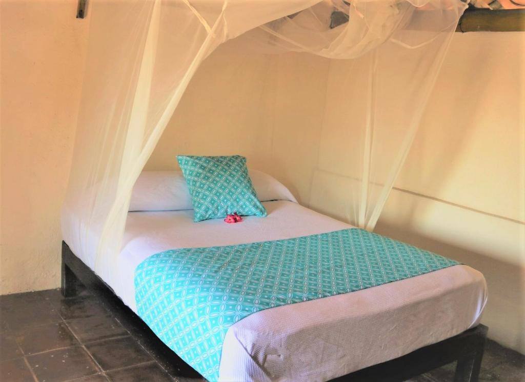 een klein bed in een kamer met een baldakijn bij Casa de la Gente Nube in Puerto Escondido