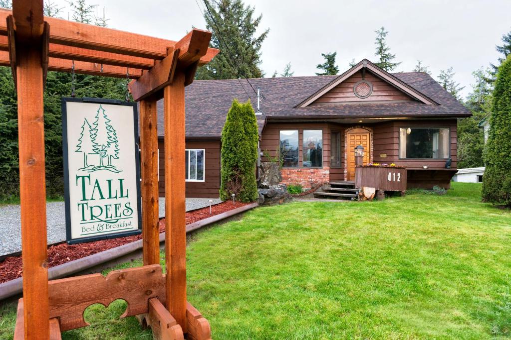 una casa con un cartel delante de un patio en Tall Trees Bed & Breakfast, en Prince Rupert