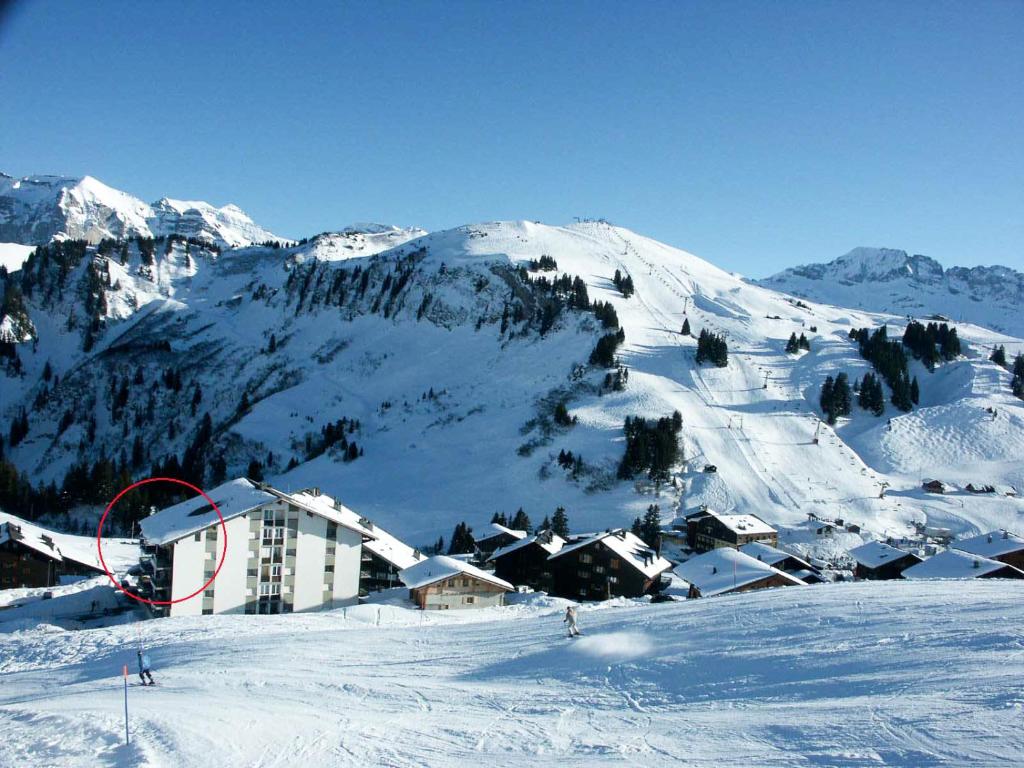 une montagne enneigée avec un lodge de ski sur une piste de ski dans l'établissement Les Crosets Apartment Miroi 23, Val d'Illiez, à Les Crosets