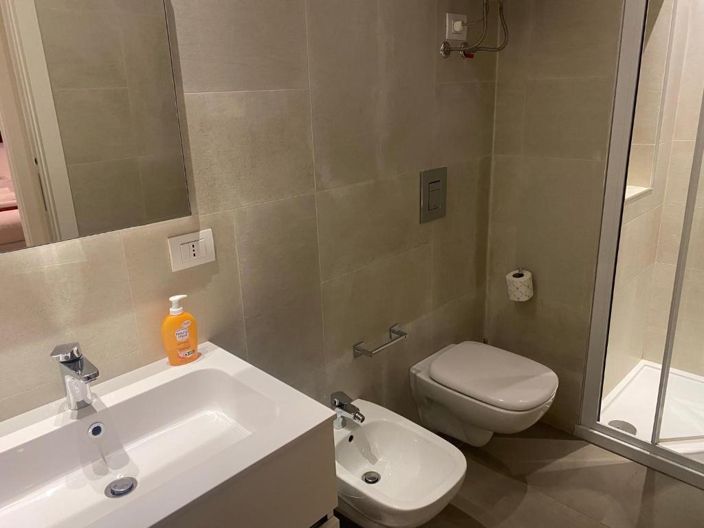 Un baño con lavabo, inodoro y espejo. en Futura Exclusive Suite 1, en Bari