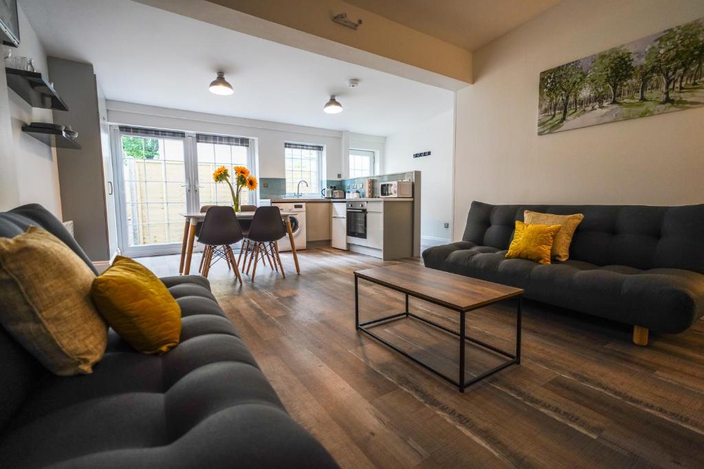 a living room with two couches and a table at Private, Detached Annex with On-Street Parking in Cardiff