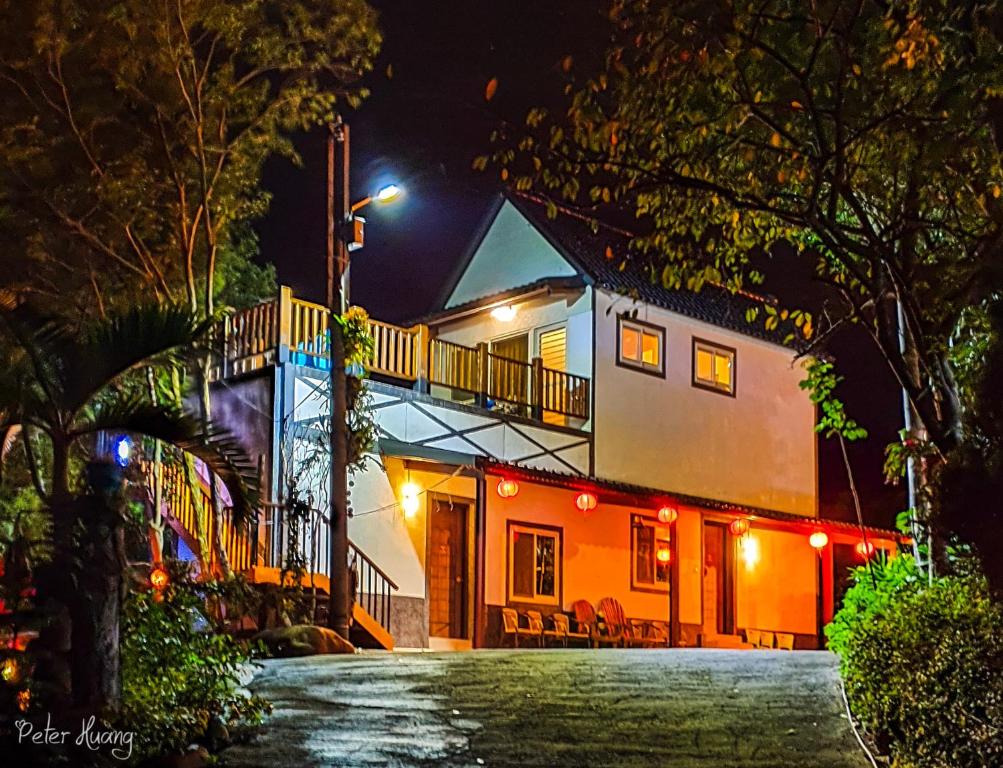 a house with a balcony on a street at night at Fei Ying Homestay in Tongxiao