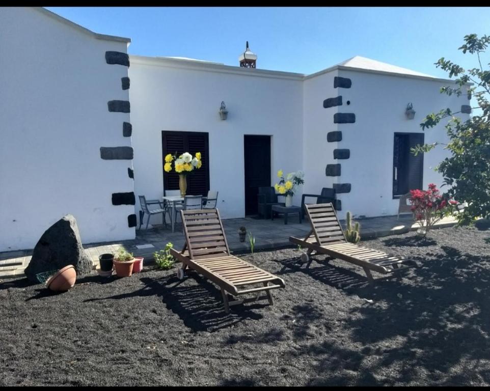 un grupo de sillas frente a un edificio blanco en Numero28,Casa Tilama, en Uga