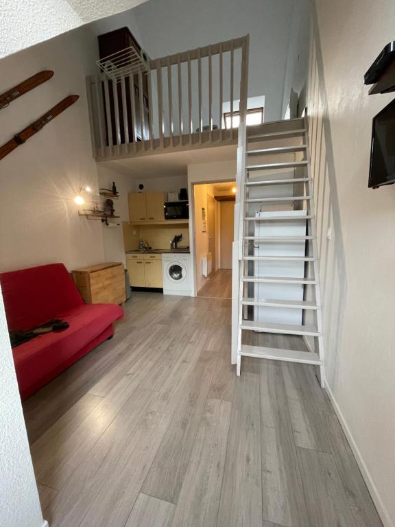a living room with a staircase and a red couch at Residence les bleuets in Saint-Pierre-de-Chartreuse