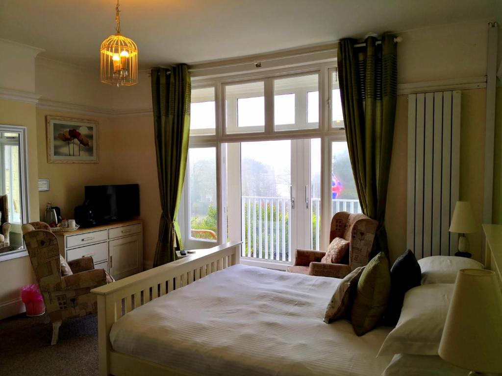 a bedroom with a bed and a large window at Sunset Guest House in Hunstanton