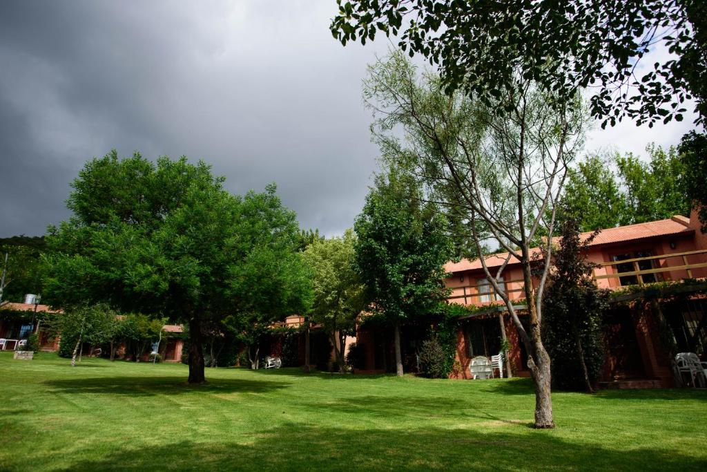 um edifício com árvores em frente a um pátio verde em Los Almendros em La Cumbre