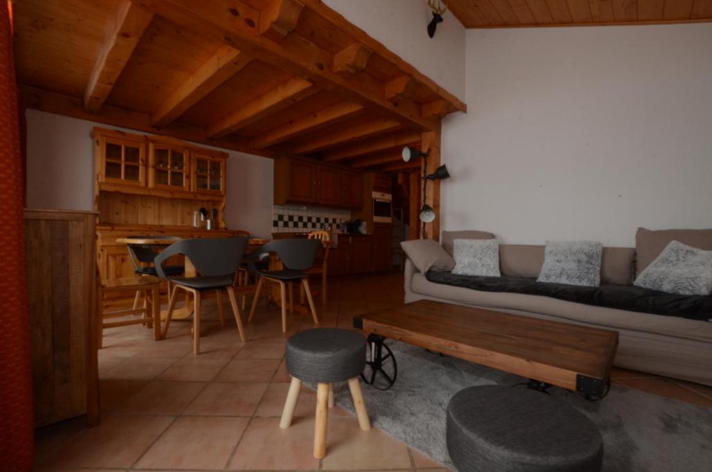 uma sala de estar com um sofá e uma mesa em Chalet A, Village des Lapons Les Saisies, 3 chambres et 1 espace nuit mezzanine em Les Saisies
