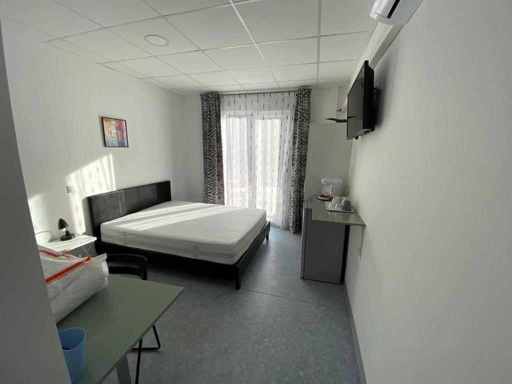 ein Krankenhauszimmer mit einem Bett, einem Schreibtisch und einem TV in der Unterkunft Domaine des Anges in Amélie-les-Bains-Palalda