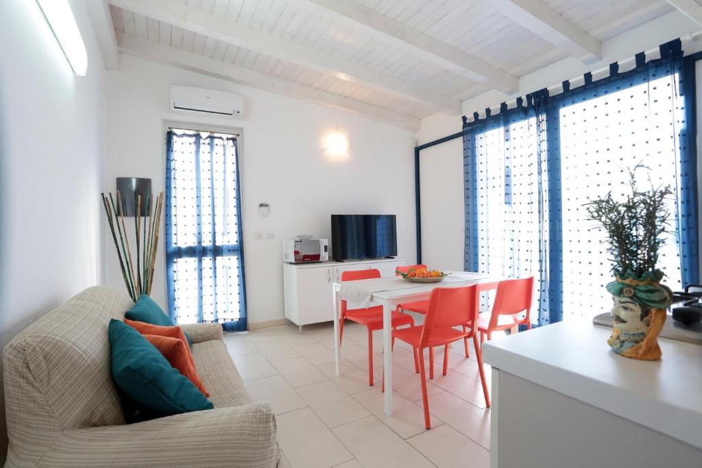 eine Küche und ein Wohnzimmer mit einem Tisch und Stühlen in der Unterkunft Casa Canoa - Le chiavi degli Iblei in Punta Braccetto