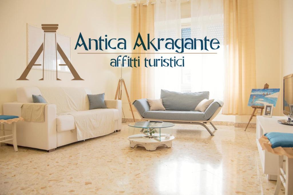 un soggiorno con 2 divani e un tavolo di Antica Akragante Apartment Agrigento con parcheggio a Agrigento