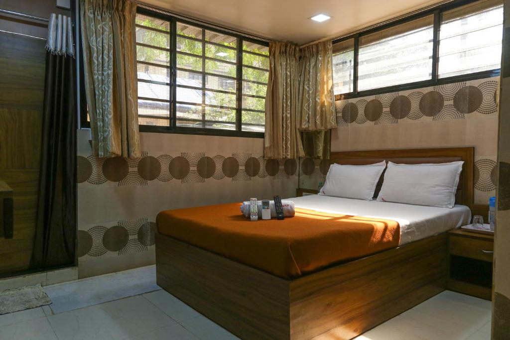 a bedroom with a bed and a shower and windows at Welcome Guest House in Mumbai