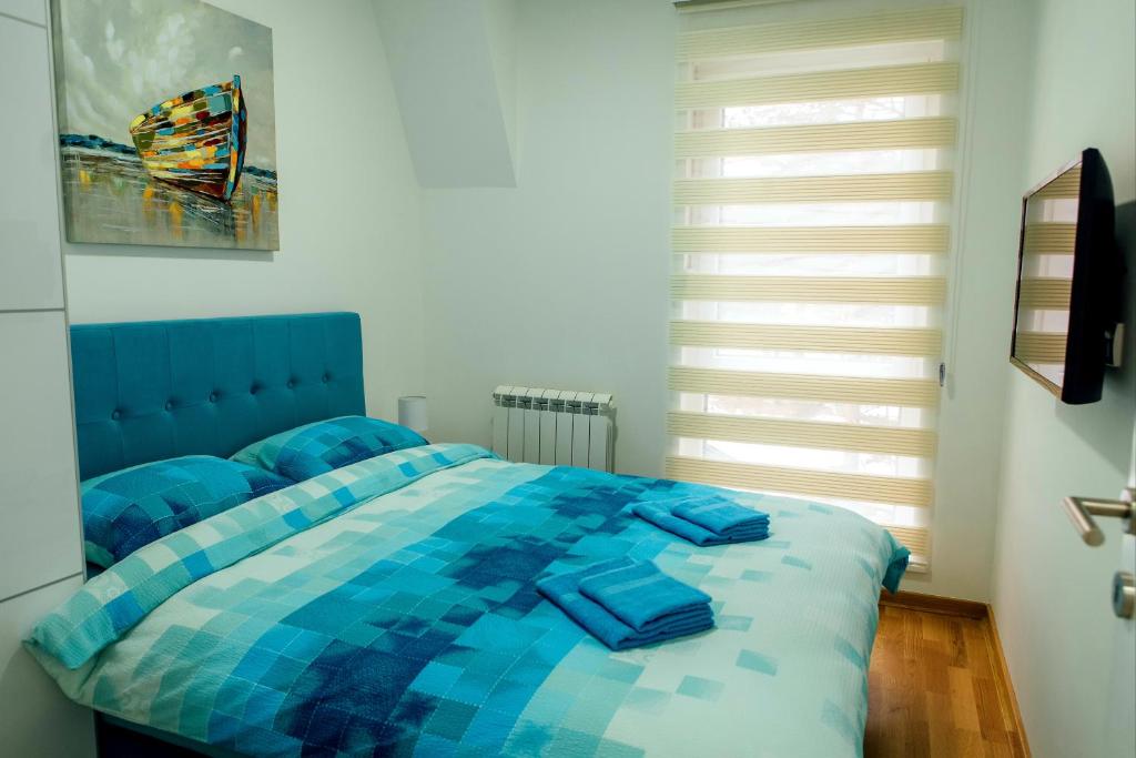 ein Schlafzimmer mit einem blauen Bett mit blauer Decke in der Unterkunft Apartman Happy day Divčibare in Divčibare