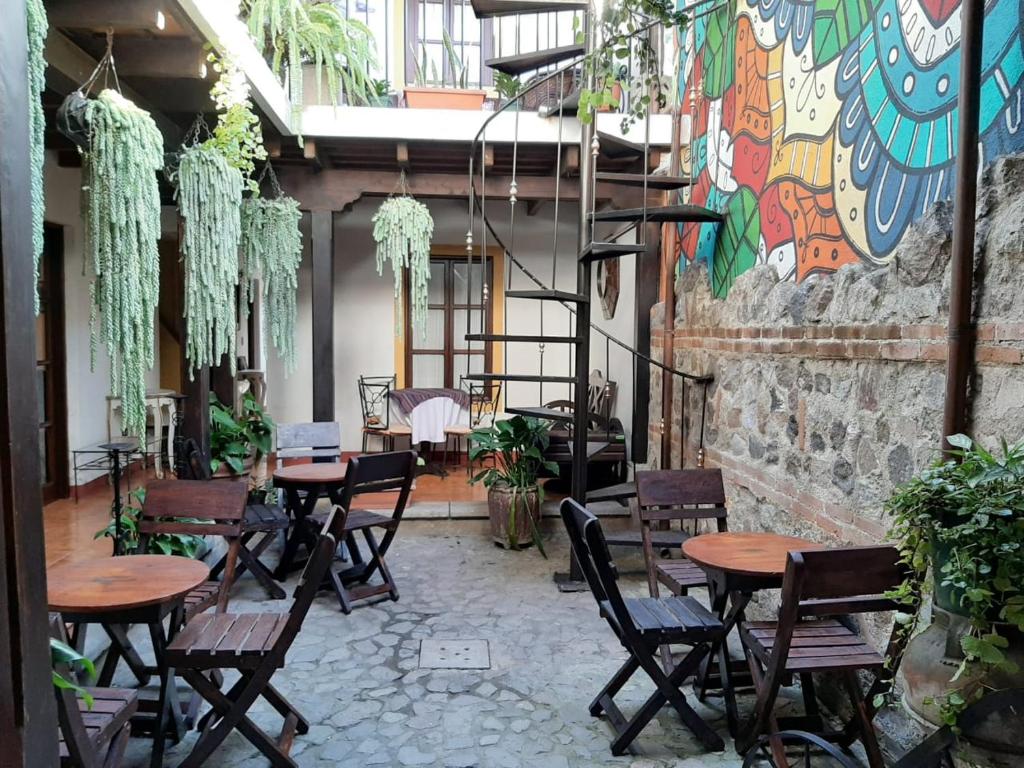 um restaurante com mesas e cadeiras de madeira e um mural em Hotel T KON T em Antigua Guatemala