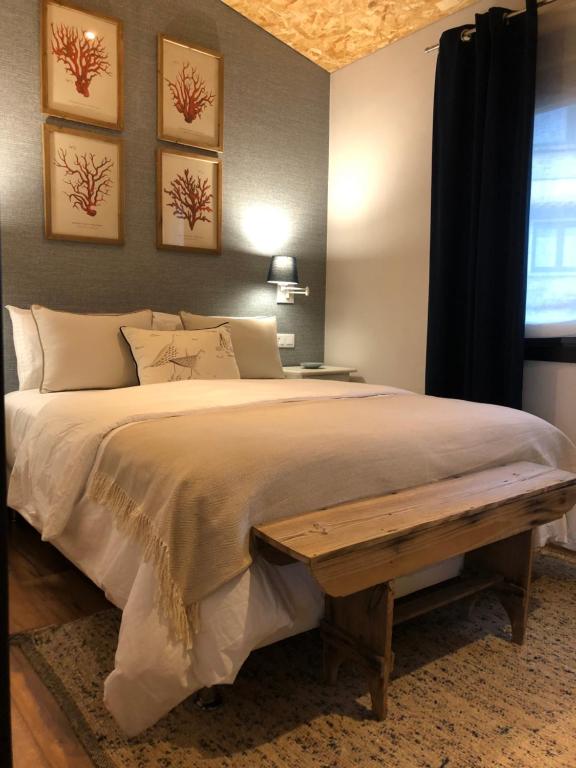 Un dormitorio con una cama grande con un banco. en CERQUIDE3, en Vigo