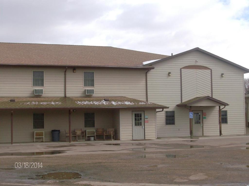 ein großes weißes Gebäude mit einer Veranda und Tischen in der Unterkunft King's Inn of Platte in Platte