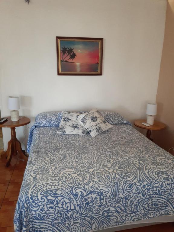 1 cama en un dormitorio con una foto en la pared en Atardecer porteño, en Puntarenas
