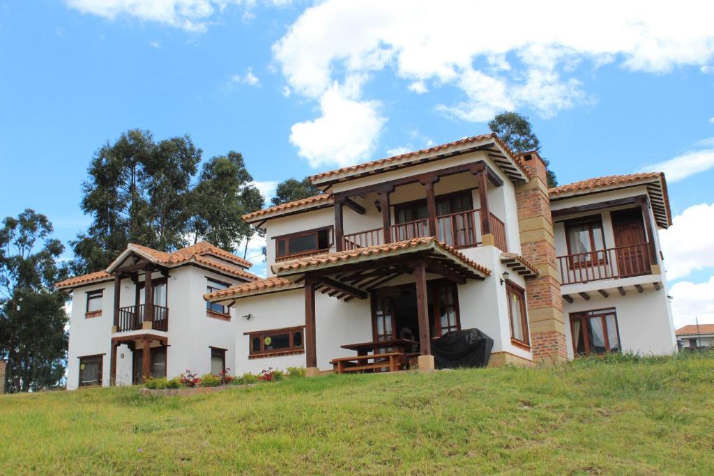 une maison au sommet d'une colline herbeuse dans l'établissement Casa Campestre San Jorge, à Villa de Leyva