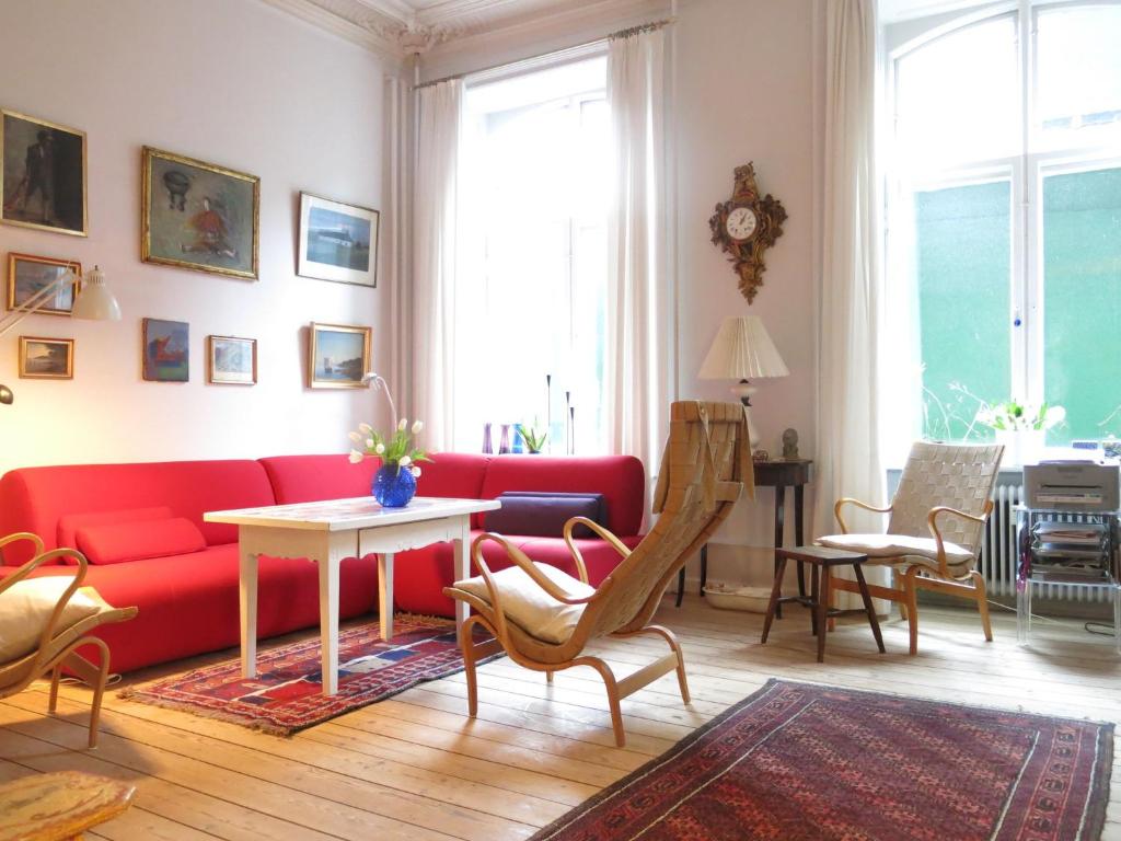 sala de estar con sofá rojo y mesa en ApartmentInCopenhagen Apartment 931, en Copenhague