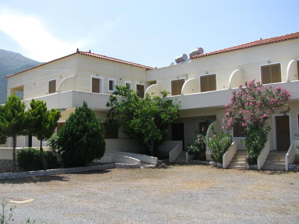 a large white building with trees in front of it at Skoutari Beach Hotel in Skoutari