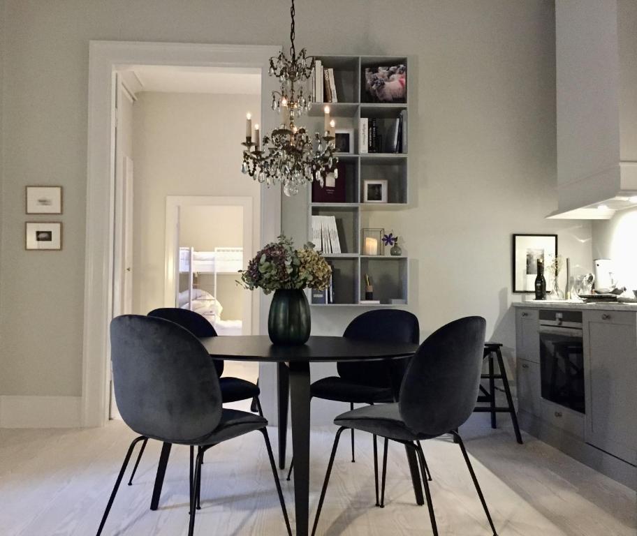 una mesa de comedor con sillas y un jarrón con flores en ApartmentInCopenhagen Apartment 1184 en Copenhague
