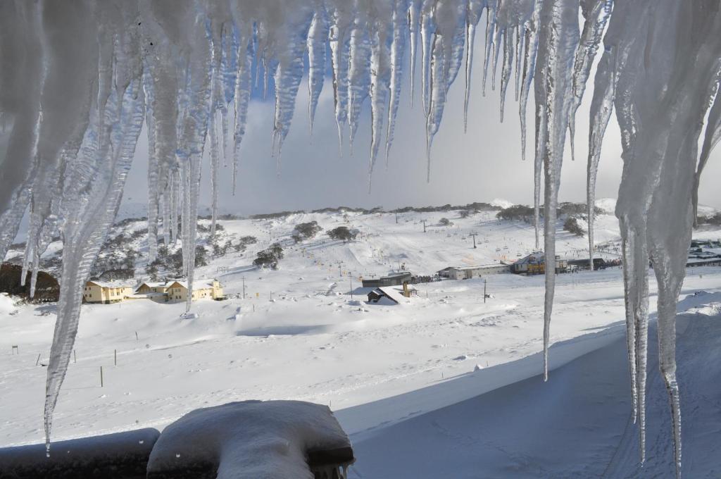 a bunch of icicles hanging from a window in the snow at Salzburg Apartments in Perisher Valley