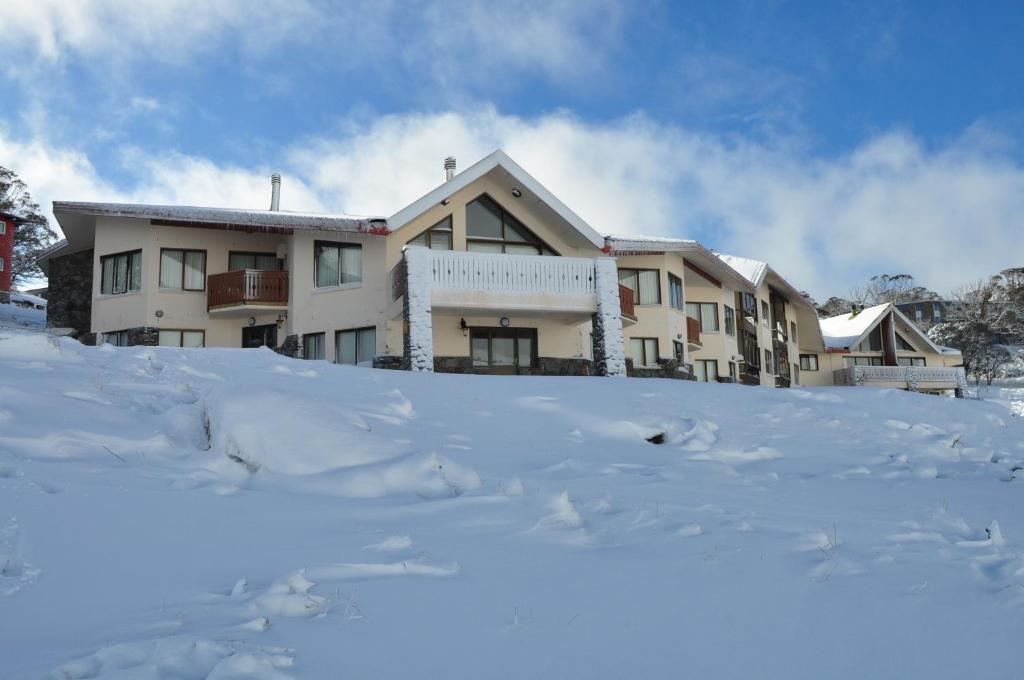 a building in the snow with a pile of snow at Salzburg Apartments in Perisher Valley