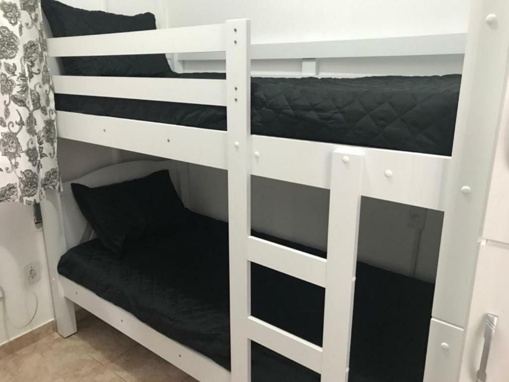 a white bunk bed with a chair in a room at Quarto Leme in Rio de Janeiro