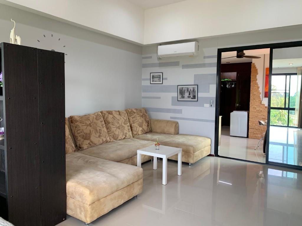a living room with a couch and a table at Condo AVANTA Deluxe A408 in Koh Samui 