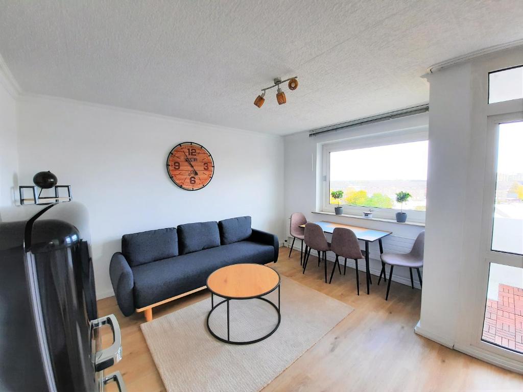 uma sala de estar com um sofá azul e uma mesa em Ferienwohnung Seestern 78 em Bremerhaven
