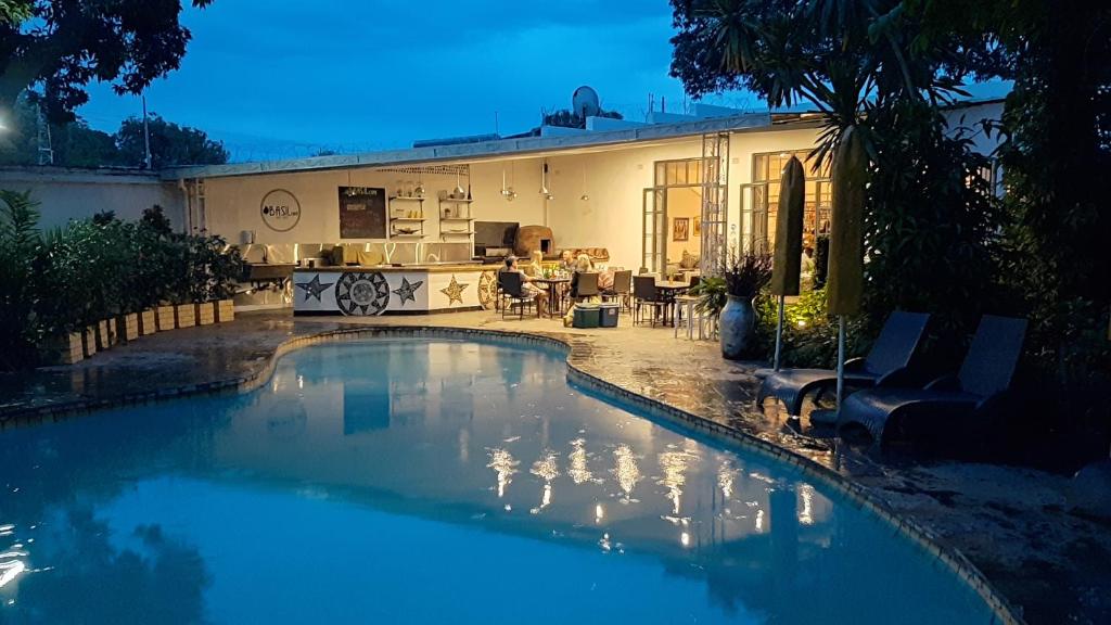 a swimming pool in front of a house at Fawlty Towers Accommodation & Activities in Livingstone