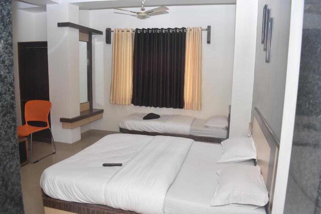 Postel nebo postele na pokoji v ubytování HOTEL SAI VISHVA KARMA
