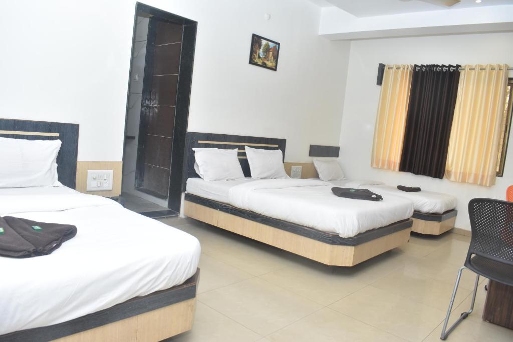 Postel nebo postele na pokoji v ubytování HOTEL SAI VISHVA KARMA