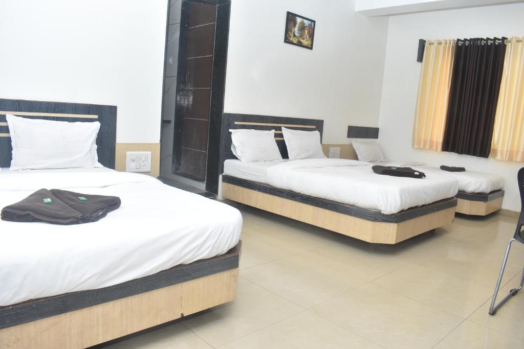 Postel nebo postele na pokoji v ubytování HOTEL SAI VISHVA KARMA