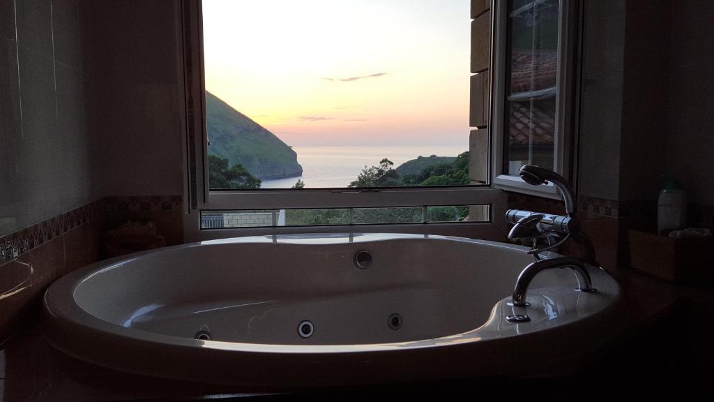 a bath tub in a bathroom with a large window at Playasonabia in Oriñón