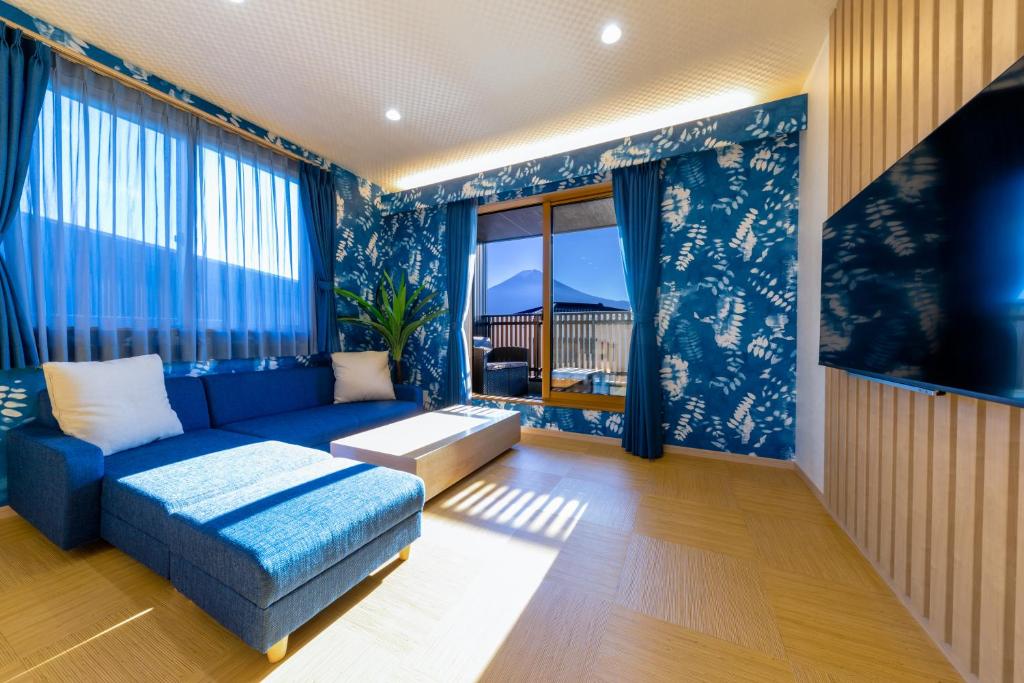 uma sala de estar com paredes azuis e um sofá azul em 02 Resort Club -蒼SOU- em Fujikawaguchiko