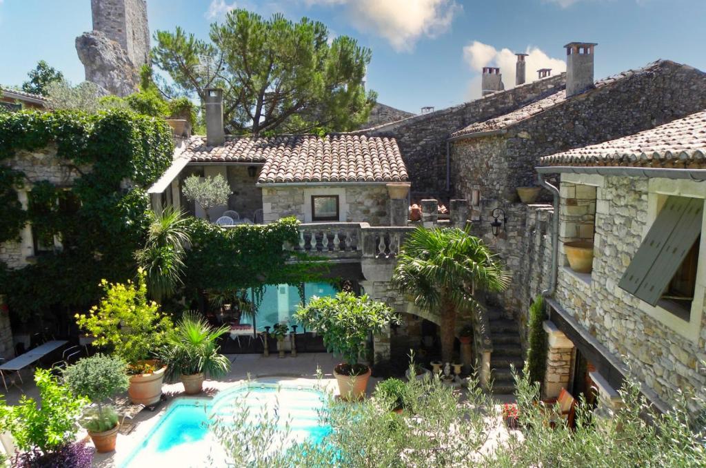 an exterior view of a house with a swimming pool at Le Castélas in Aiguèze