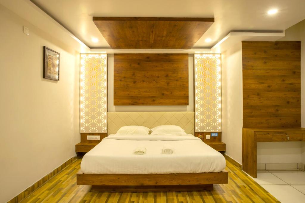 1 dormitorio con 1 cama con sábanas blancas y ventana en Oaks Residency en Bekal