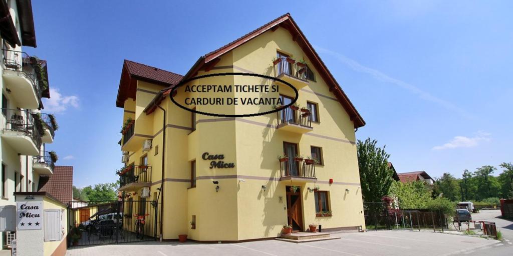 un edificio amarillo con un cartel en el costado en Casa Micu en Sibiu