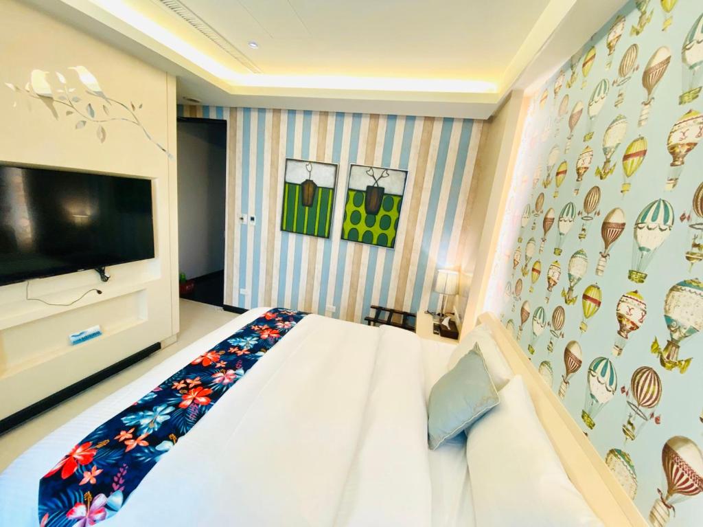 a bedroom with a bed and a wall with a tv at 日月潭天月水色民宿 (老街-停車-度假）skylight bnb in Yuchi