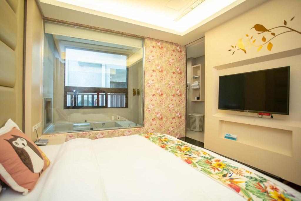 a bedroom with a large bed and a television at 日月潭天月水色民宿 (老街-停車-度假）skylight bnb in Yuchi
