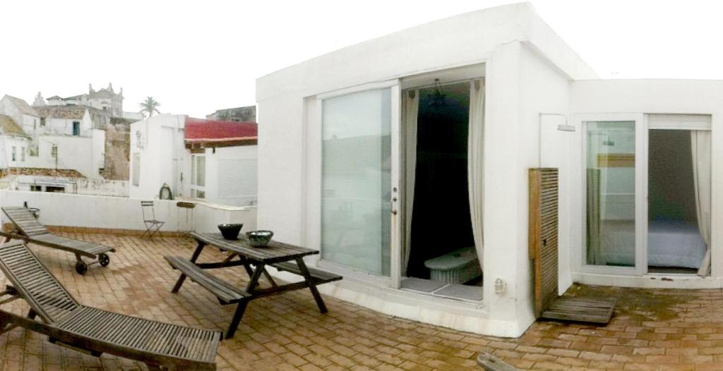 einen Balkon mit einem Tisch und Stühlen auf einem Gebäude in der Unterkunft Apartamentos Casa del Coronel in Tarifa