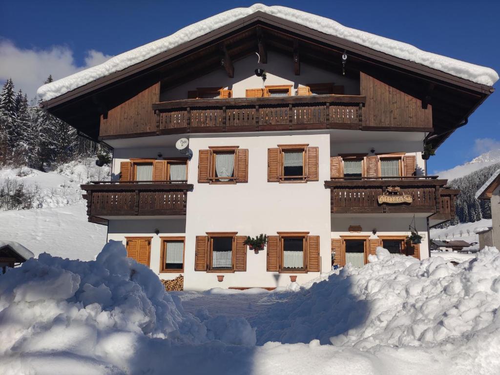 Un edificio cubierto de nieve con nieve a su alrededor. en CasaSabry, en San Nicolò di Comelico