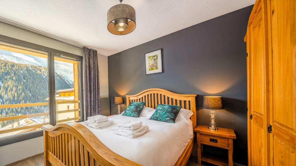 a bedroom with a bed with a large window at The View - Apt 09 - BO Immobilier in Châtel